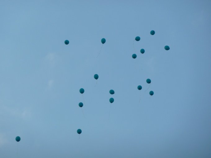17 Blaue Ballons schweben im wolkenlosen, blauen Himmel.  