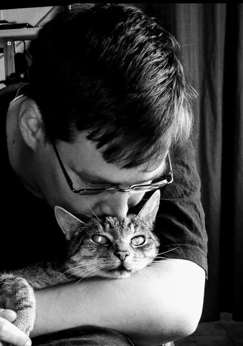 LiLaLuka hält eine Katze im Arm und beugt sich zu ihr herunter. Das Foto ist in Schwarz-Weiß. 